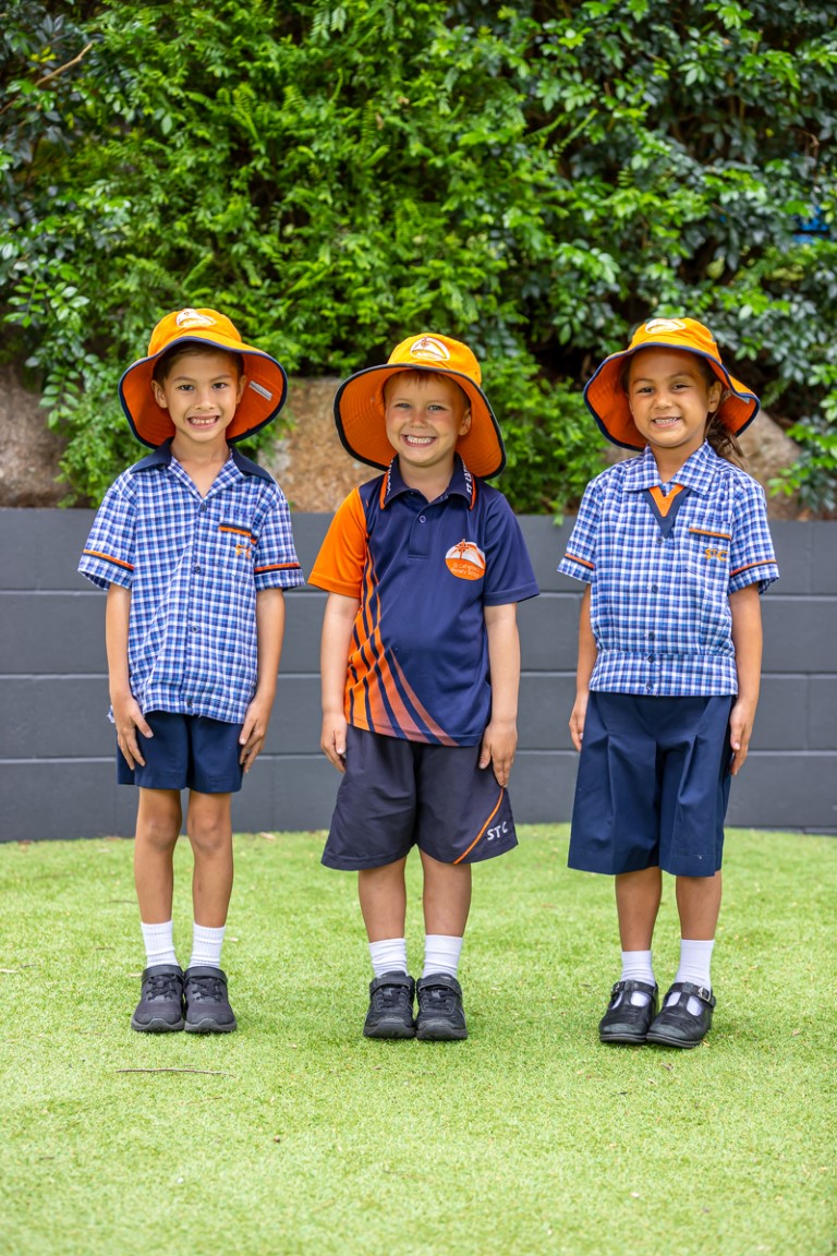 Image of three students wearing their school hats