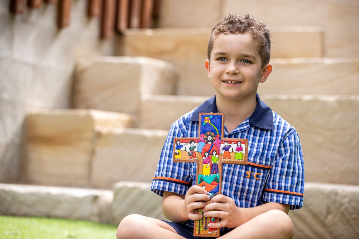 Student holding cross smiling