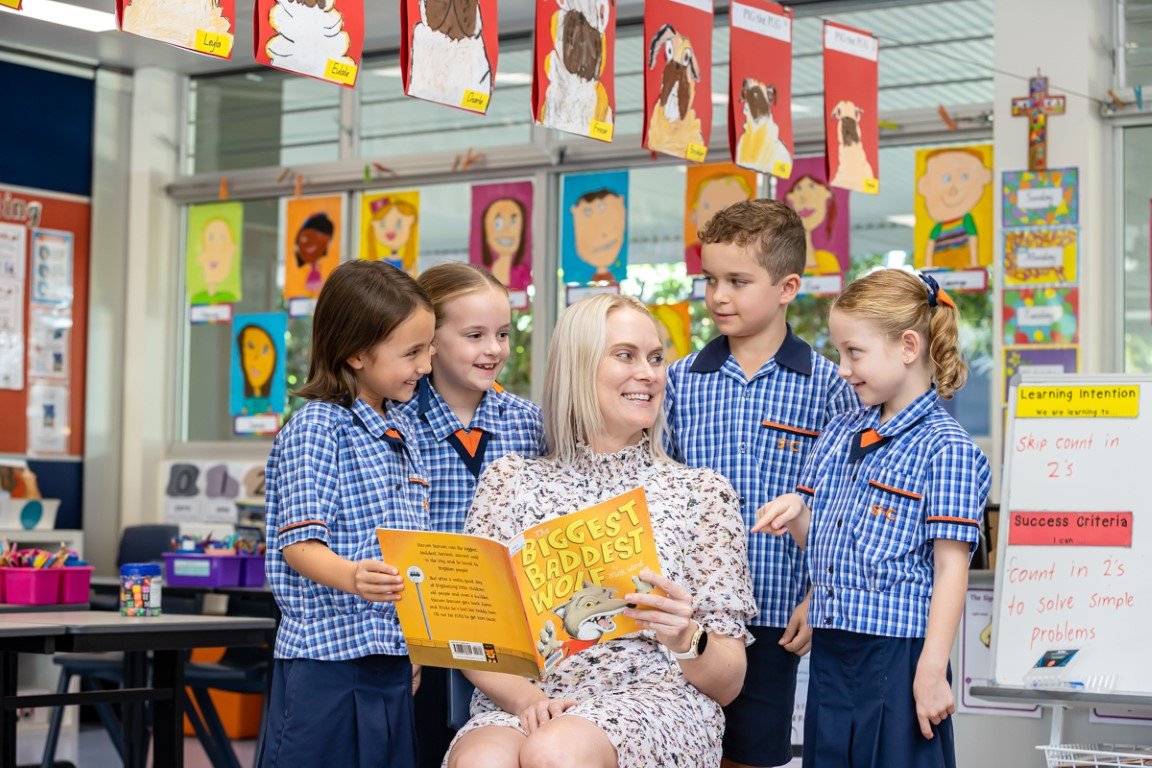Image of teacher reading a book, surrounded by four students