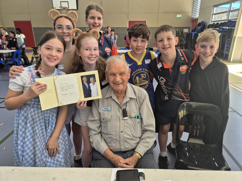 Image of Year 6 students surrounding a senior guest