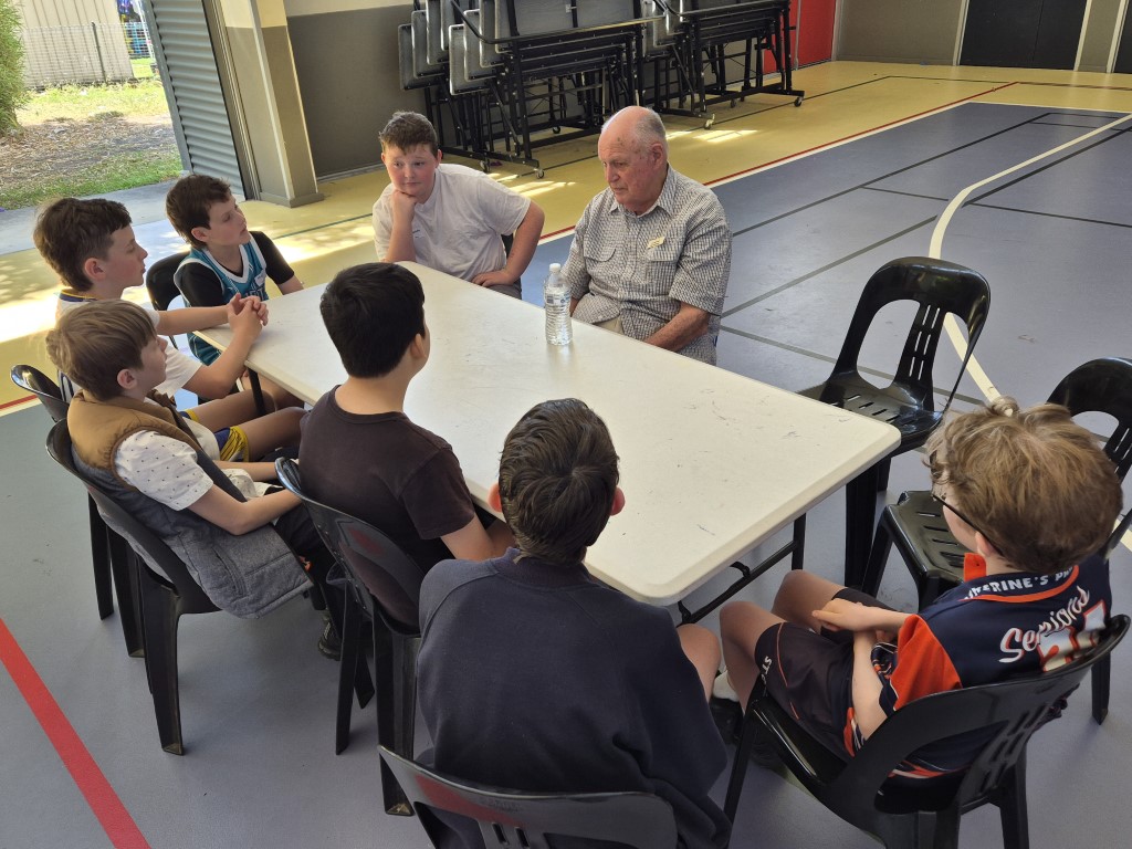 Image of Year 6 students surrounding a senior guest