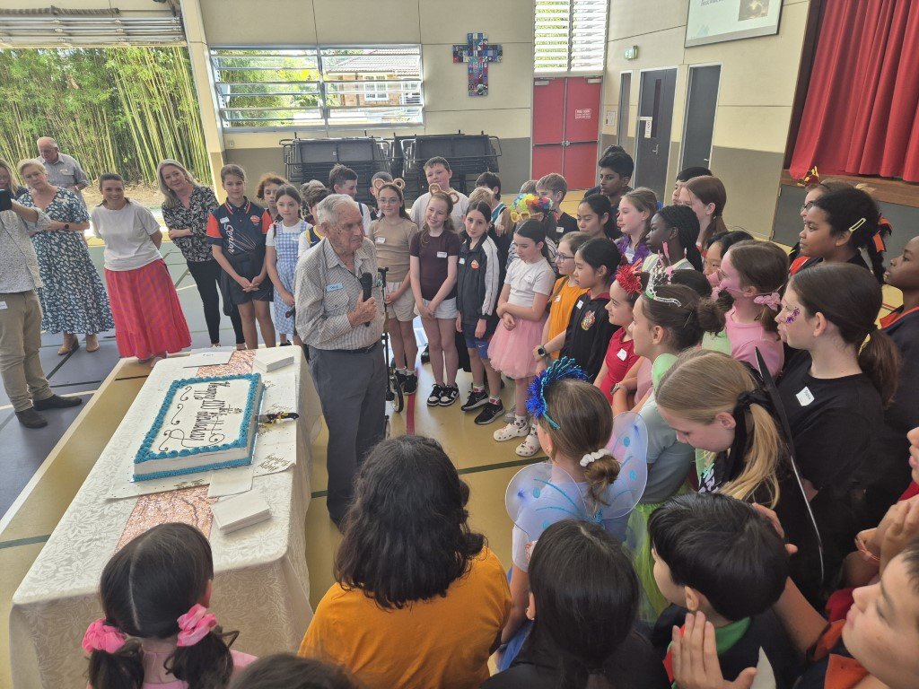 Image of a senior guest celebrating his 100th birthday with Year 6 students